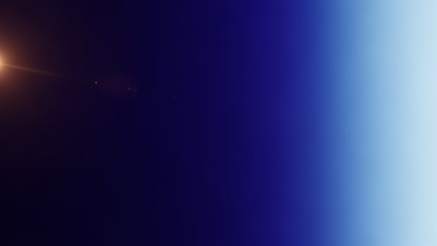 The sun is seen in the distance with a blue sky photo