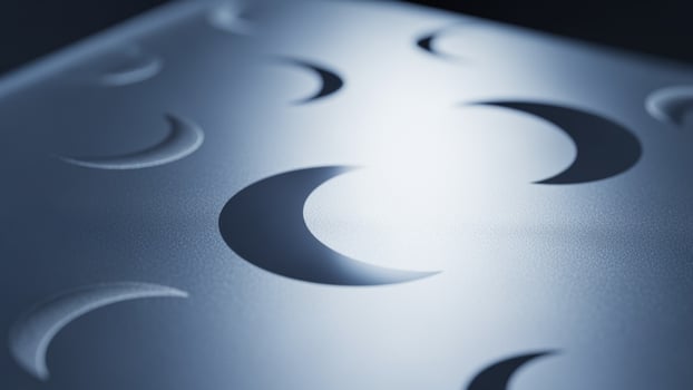 A close up of a metal surface with a moon on it photo
