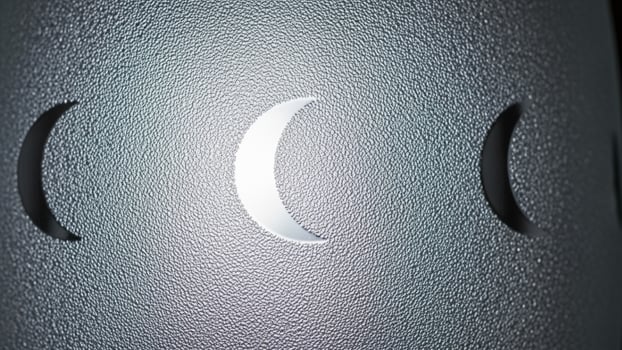 A close up of a metal object with three crescents photo