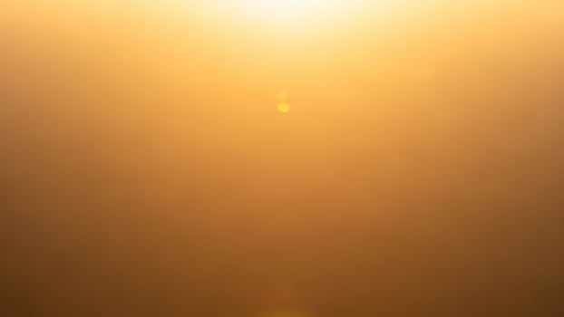 A golden sun is shining through a foggy background photo