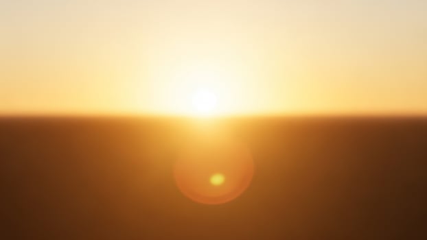 The sun is setting over a field photo