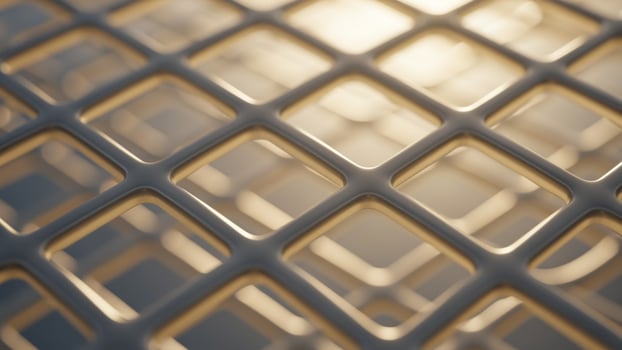 A close up of a metal mesh with a sun shining through photo