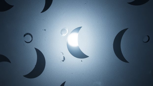A crescent moon is seen in the dark with a light shining through it photo