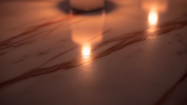 A candle is lit on a marble table photo