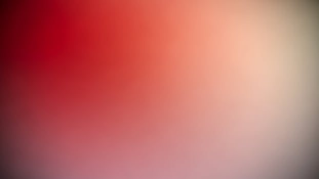 A blurry red and black background with a white object photo