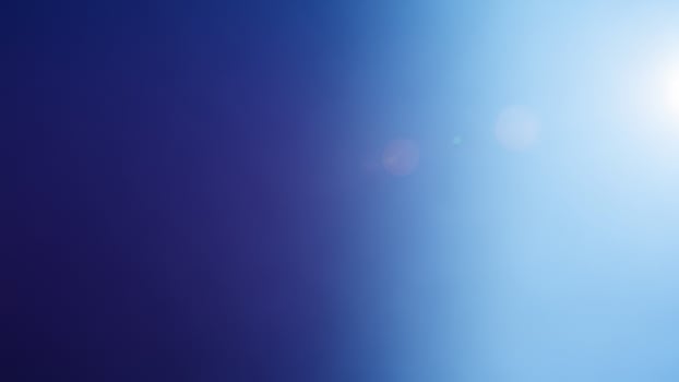 A blue and purple background with a sun shining through photo