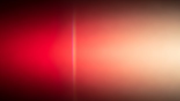 A blurry red and white light is shown in the dark photo