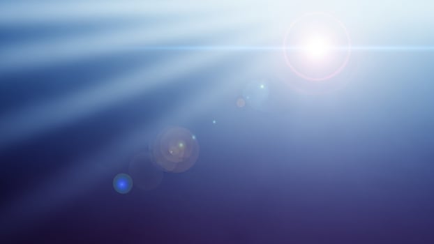 Sunlight shining through a blue sky with a bright light photo
