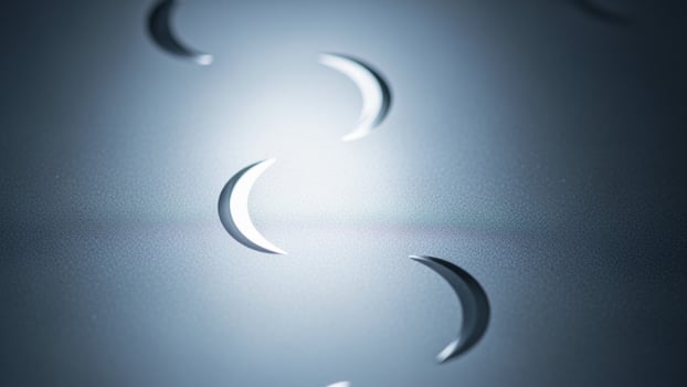 A set of three crescent moons on a metal surface photo