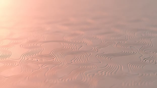 A close up of a wavy surface with a pink background photo