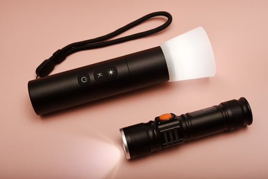 Vintage handheld flashlight. Retro-style torch with worn-out details. Placed on a wooden background. photo