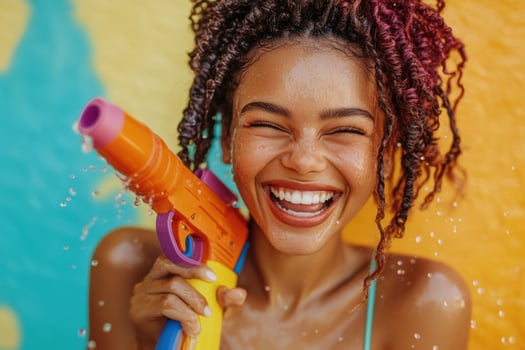 A woman is smiling while holding a water gun photo