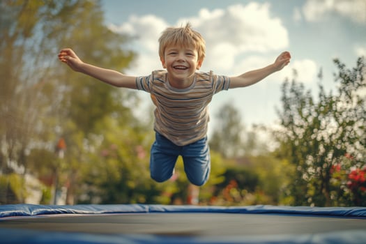 A young boy jumping on a trampoline photo