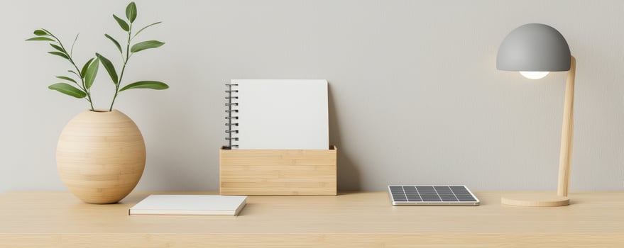 Minimalist sustainable office desk with bamboo organizer, lamp, plant, and notebook photo
