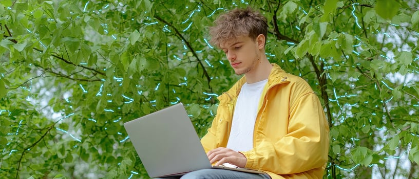 Digital nomad working outdoors with laptop in yellow jacket photo