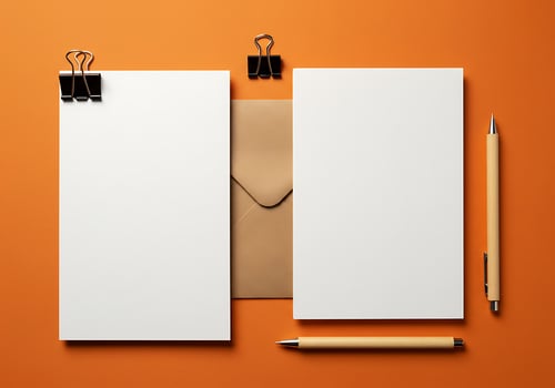 Blank paper, pen and pencil on orange background photo