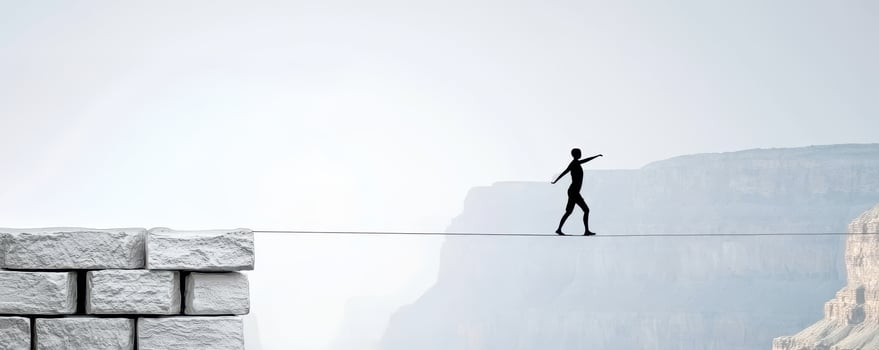 Goal of life and perseverance achievement concept, Silhouette of person walking on tightrope over cliffs photo