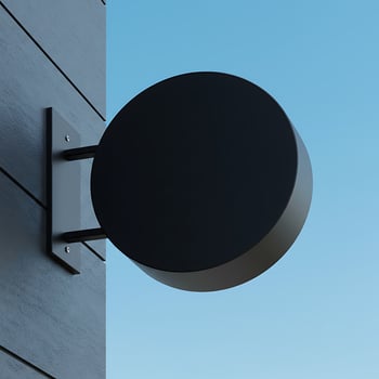 A black round sign on a wall photo