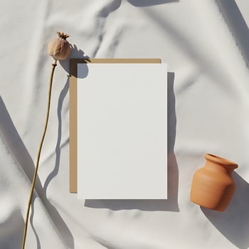 Blank paper and vase on white cloth photo