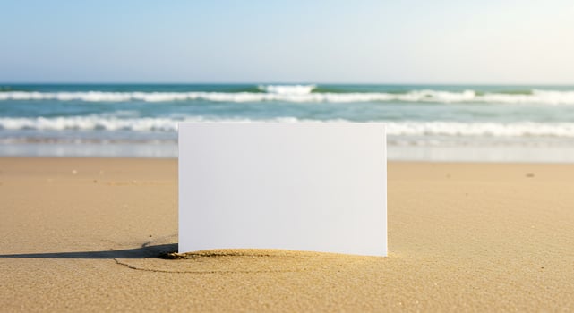 Blank paper on the beach with ocean in background photo