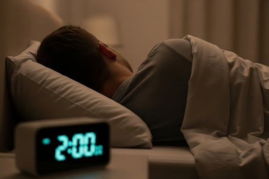 Man Sleeping at 2 AM, Illuminated Alarm Clock, Bedtime, Restful Sleep. photo