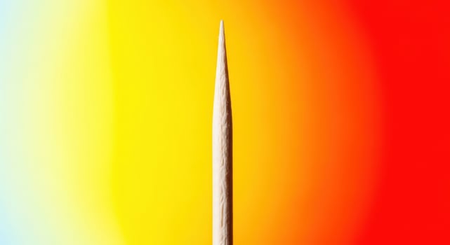 Close up of a wooden toothpick against a colorful gradient background photo