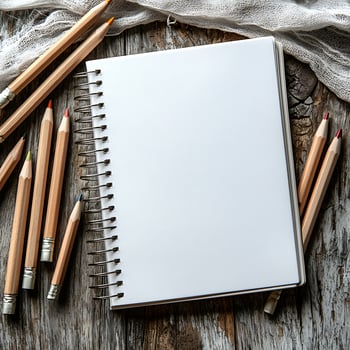 Blank Spiral Notebook with Wooden Pencils on Rustic Wooden Surface photo