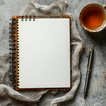 Blank Notebook and Pen on Artistic Surface with Tea Cup photo