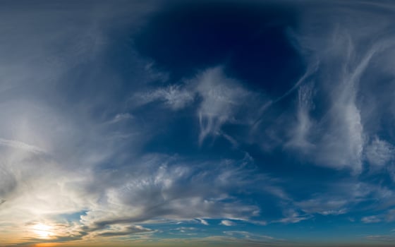 Dramatic sky with wispy clouds and setting sun photo