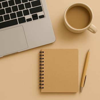 Top view of a laptop, spiral notebook, pen and coffee cup on beige background. Warm, minimalist workspace scene for productivity or remote work. photo