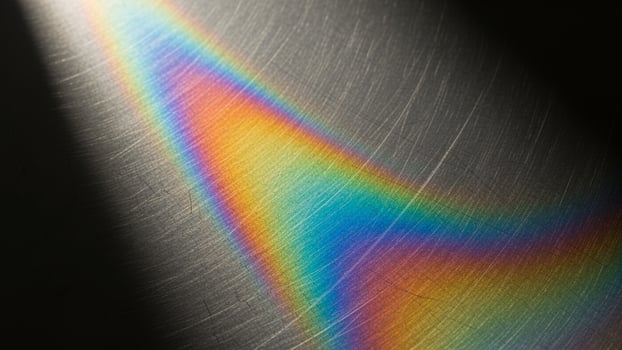 A rainbow light is shining on a metal surface photo