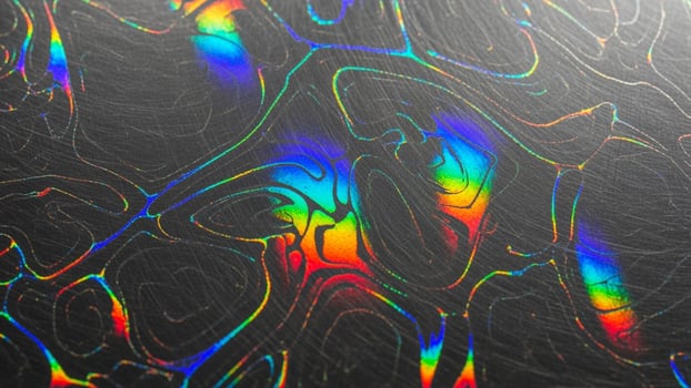 A close up of a rainbow colored pattern on a black surface photo