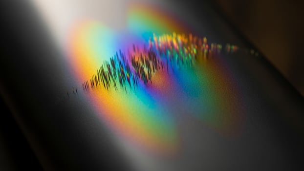 A rainbow colored sound wave is reflected off of a metal surface photo