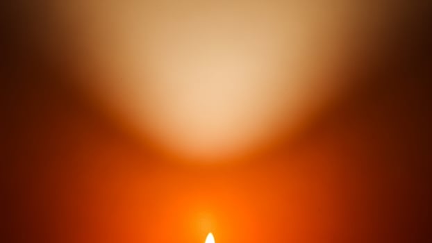 A candle is lit in the dark with a bright light photo