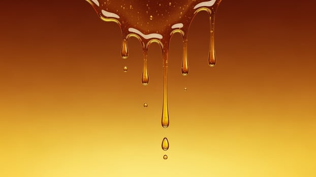 A dripping syrup is shown on a yellow background photo