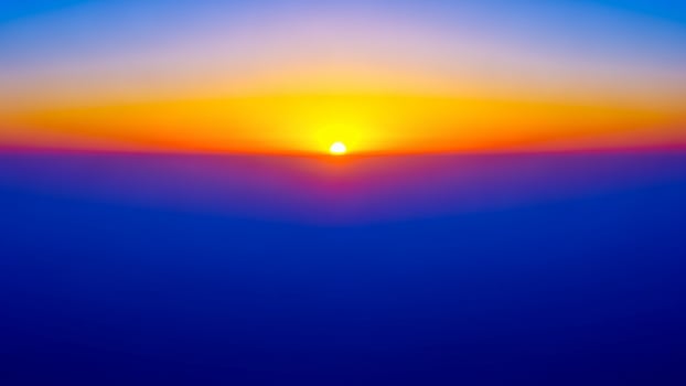 The sun is setting over a blue ocean photo