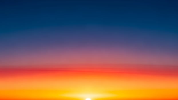 A sunset over the ocean with a bright orange and blue sky photo