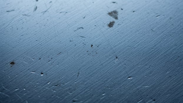 A blue metal surface with scratches and dirt photo