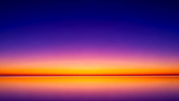 A sunset over the ocean with a purple and blue sky photo
