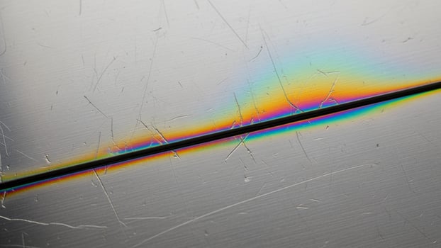 A rainbow colored line on a metal surface photo