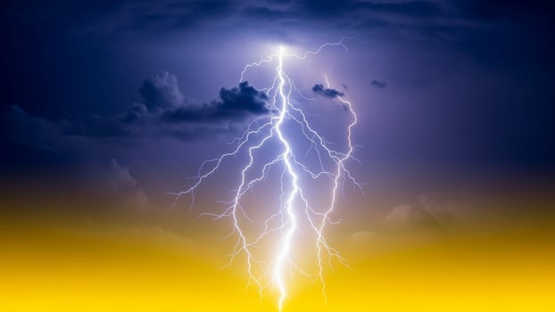 Lightning bolt striking the sky with clouds in the background photo