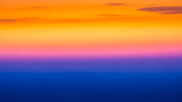 A colorful sunset over the ocean with a blue sky photo