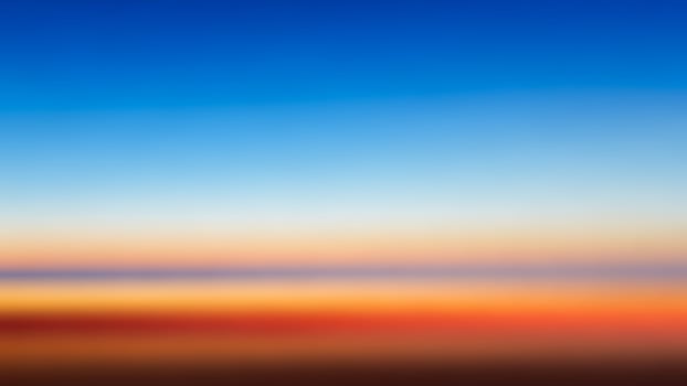 A blurry image of a sunset with a blue sky photo