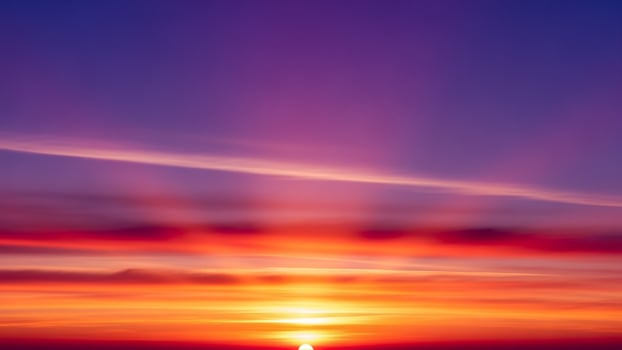 A beautiful sunset over the ocean with the sun shining brightly photo