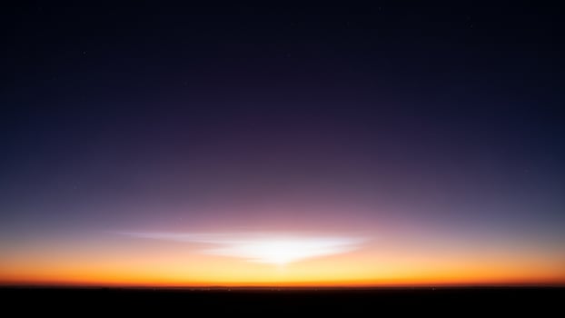 A sunset over the horizon with a bright light photo