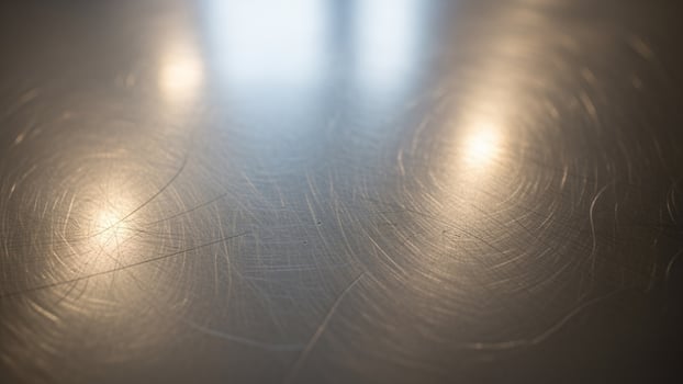 A shiny metal surface with some scratches photo