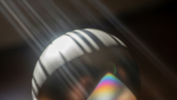 A silver spoon with a rainbow light shining through it photo