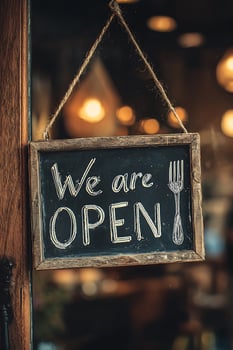 Charming Chalkboard 'We are OPEN' Sign with Fork, Hanging on a Glass Door with Cozy Lights photo