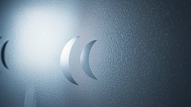 A close up of a metal door with a light shining through it photo