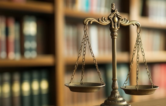 Vintage balance scale symbolizing justice against bookshelf blurred backdrop photo